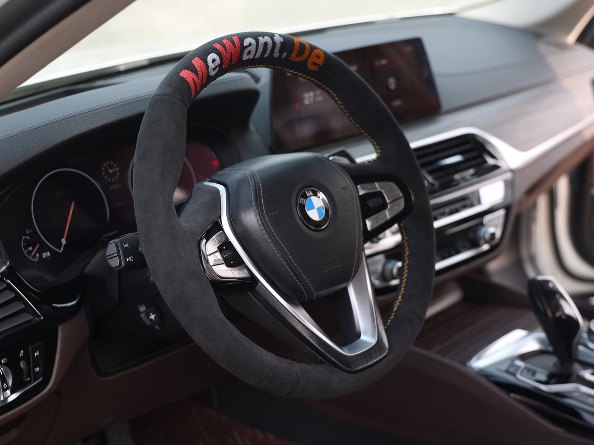 BMW-Lenkrad mit dunklem textilem Bezug und farbig gesticktem Mewant.De-Schriftzug